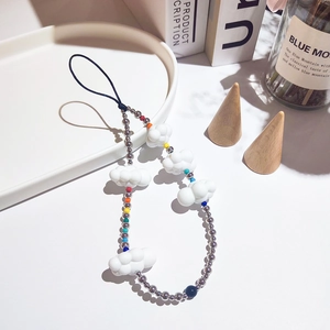 Handmade beaded phone strap with white acrylic clouds and colorful beads on a white tray