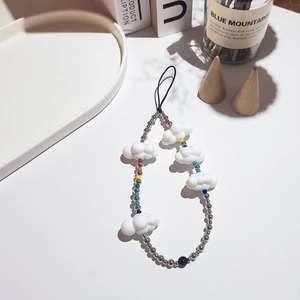 Handmade phone strap with white acrylic clouds and colorful beads on a white surface