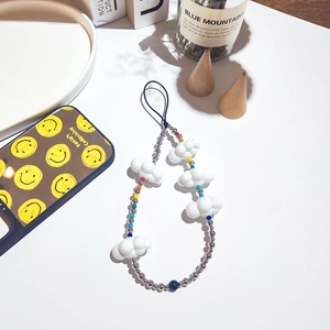 Close-up of handmade phone charm featuring white acrylic clouds and colorful beads