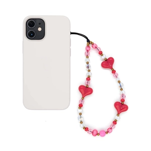 Pink heart beaded phone charm with pearls and crystal beads on a white phone