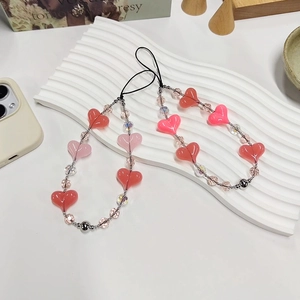 Detail of beaded phone straps with pink and orange acrylic hearts on a white display