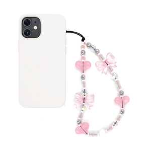 Pink and silver beaded phone charm with heart and bow design on white smartphone