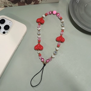 Handmade phone strap featuring red hearts and faux pearls for a trendy aesthetic look
