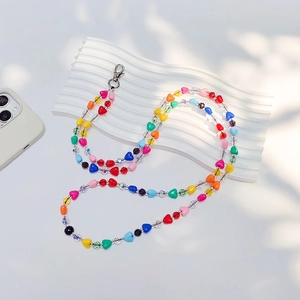 Dragonne de téléphone perlée en forme de cœur coloré avec fermoir en métal argenté sur blanc