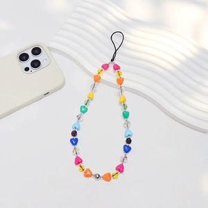 Bijou de téléphone avec perles de cœur colorées et perles de cristal sur fond blanc pur