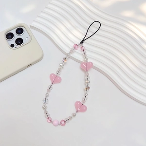 Handmade beaded phone strap with pink acrylic hearts and white pearls on white tray