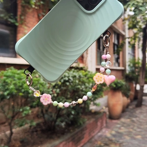 Colorful macaron beaded phone charm with flowers and heart pendant on a ripple case
