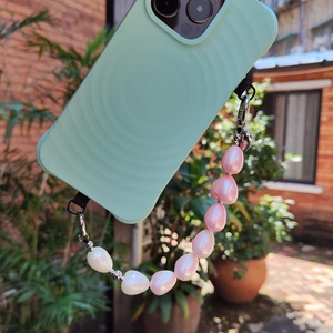 Mint green phone case with wavy texture and beaded heart charm lanyard on silver metal hooks