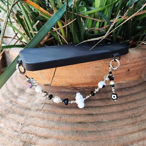 Handmade black and white beaded phone strap with butterfly, star, and flower charms