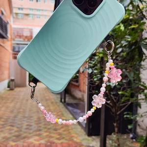 Sweet pink floral phone charm with imitation pearls and beads on a wavy mint green case