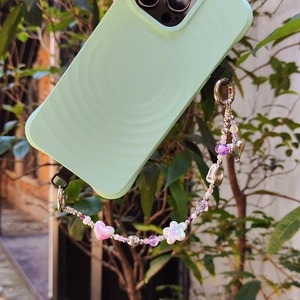 Detail of mint green silicone phone case with colorful heart and floral beaded wrist strap