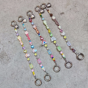 Detail of colorful acrylic beaded charms with metal heart clasps and letter beads