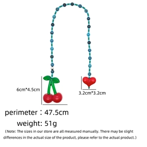 Detail view of handmade blue bead chain with red cherry and heart pendants and size labels
