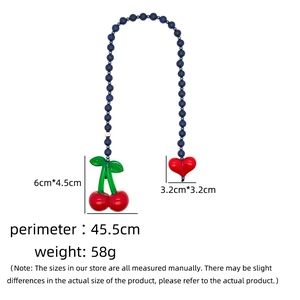 Close-up of beaded bag charm featuring red cherry and heart pendants with size dimensions