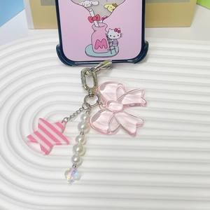 Pink resin bow phone charm with star pendant and white pearl beads on white tray