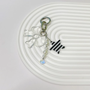 Detail of butterfly phone charm with pearls, star ornament, and crystal pendant