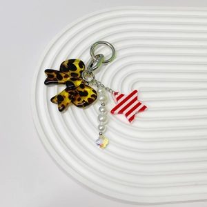 Detailed view of leopard print bow and striped star keychain with faux pearls