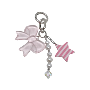 Detail of pink resin bow, pearl chain and star charm on a silver-tone metal keychain