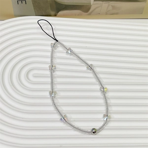 Chic phone wrist strap with matte grey beads and iridescent butterfly charm on white tray