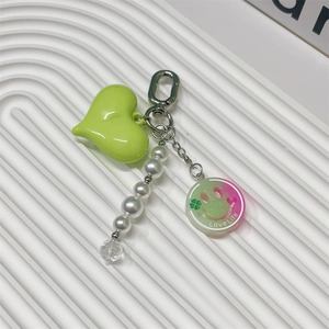 Detail of sweet bow phone charm with green heart, pearls, and Love Life acrylic tag
