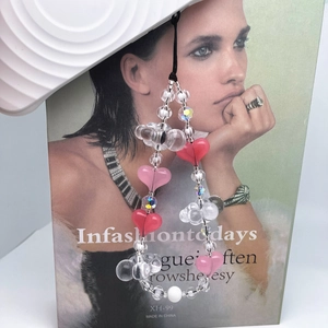 Sweetheart beaded phone strap with pink heart charms and clear crystals on a magazine background