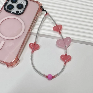 Pink heart beaded phone charm strap attached to a semi-transparent magnetic phone case