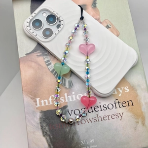 Colorful beaded phone strap with clear acrylic crystals and pink heart charms on white case