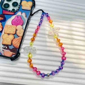 Colorful beaded phone wrist strap with yellow bow on a white textured background