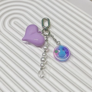 Detail of Y2K butterfly style keychain with purple heart charm and pearl strap