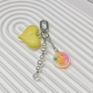 Detail of yellow heart keychain with pearls and Love Life charm for bag decoration