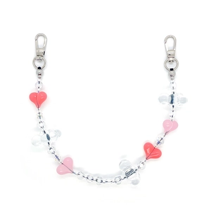Close-up of pink heart and clover beads with silver lobster clasps on phone lanyard