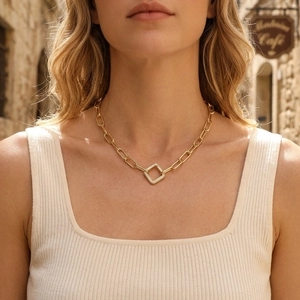 Close-up of gold chunky link chain necklace with a sparkling diamond pavé rhombus pendant
