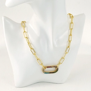 Close-up of golden thick chain necklace with a rainbow zircon oval pendant on mannequin