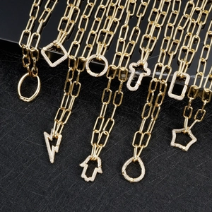 Detail of gold paperclip chain necklaces with micro-paved zircon geometric pendants