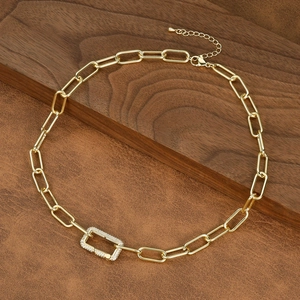 Detail of gold paperclip chain necklace with a pave crystal rectangle clasp on leather