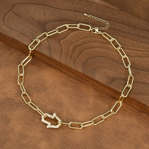 Detail of gold paperclip chain necklace with a diamond-set Hamsa Hand pendant