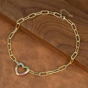 Detailed shot of golden paperclip chain necklace with a colorful zircon heart pendant