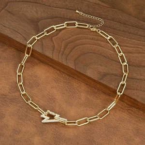Detail of gold paperclip link necklace with a lightning bolt pendant set with cubic zirconia