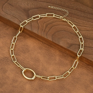 Detailed close-up of a gold paperclip chain necklace with a large oval connector link