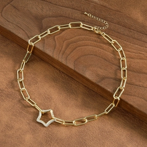 Detail of gold paperclip chain necklace with a star pendant encrusted with micro zircons