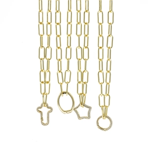 Detail of gold paperclip chains featuring cross, star, circle and oval pendants with zircons