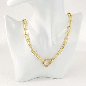 Close-up of golden paperclip link necklace with micro-pave teardrop clasp on a model