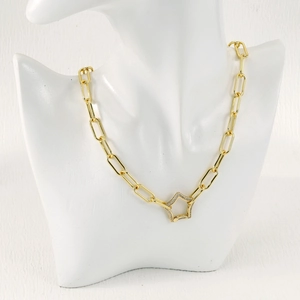 Detail of gold paperclip chain necklace with a zircon-studded star carabiner clasp