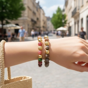 Close-up shot of multi-color semi-precious stone beaded bracelets worn on wrist outdoors.