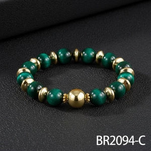 Groene kraal armband met goudkleurige metalen spacers en gelukskraal, gedetailleerde close-up.