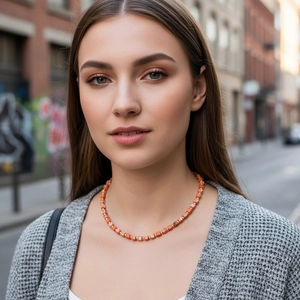 Detail of square orange stone bead necklace with silver spacers on a model