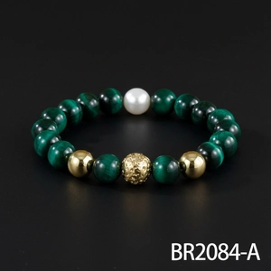 Detailed closeup of retro green gemstone beaded bracelet with gold and pearl accents.