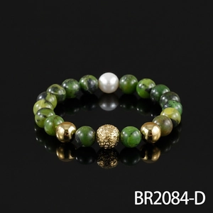 Detailed view of a retro semi-precious green stone beaded bracelet with gold and pearl accents.