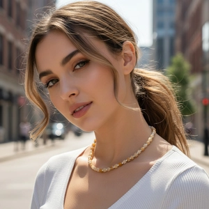 Close-up of amber beaded necklace with silver spacers on model in city background
