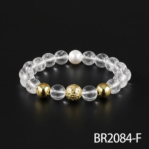 Exquisite beaded bracelet featuring clear quartz, gleaming gold beads, and an elegant pearl accent.